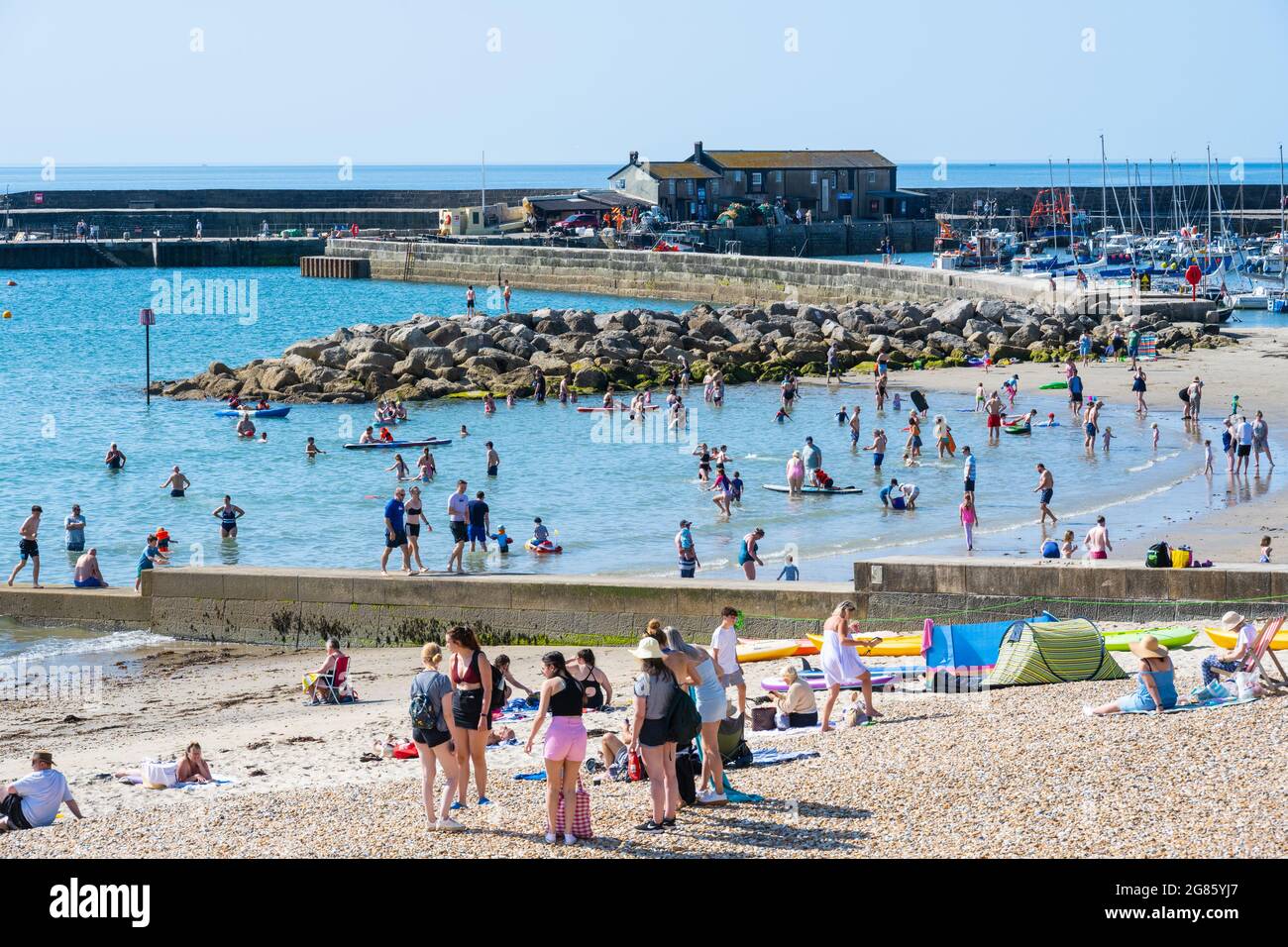 Lyme Regis, Dorset, Großbritannien. Juli 2021. UK Wetter: Ein herrlicher sonniger Start in den Tag Sonnenschein im Badeort Lyme Regis. Der hübsche Strand ist bereits vor 10 Uhr morgens voll. Kredit: Celia McMahon/Alamy Live Nachrichten Stockfoto