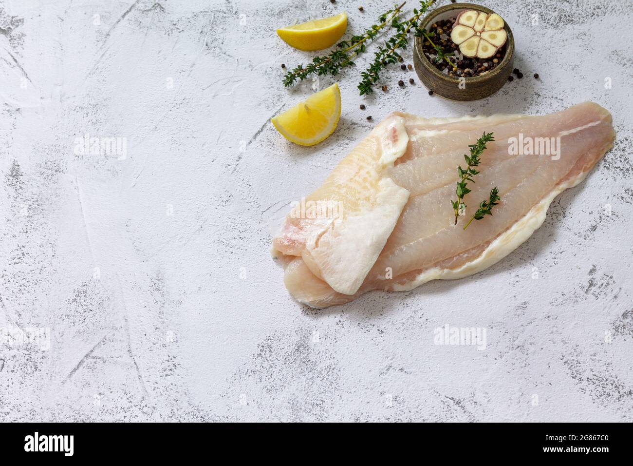 Meeresfrüchte, rohes weißes Fischfilet zum Kochen. Frisches Filet Pangasius  mit Gewürzen, Zitrone und Thymian auf steinernem Hintergrund. Speicherplatz  kopieren Stockfotografie - Alamy
