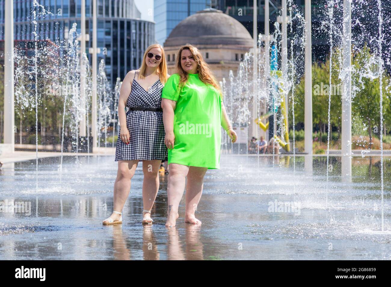 Birmingham, Großbritannien. Juli 2021. Die Instagram-Blogger Lauren B, 25, und Stacey Clarke, 37, kühlen sich im Springbrunnen-Pool auf dem Centenary Square in Birmingham ab. Peter Lopeman/Alamy Live News Stockfoto