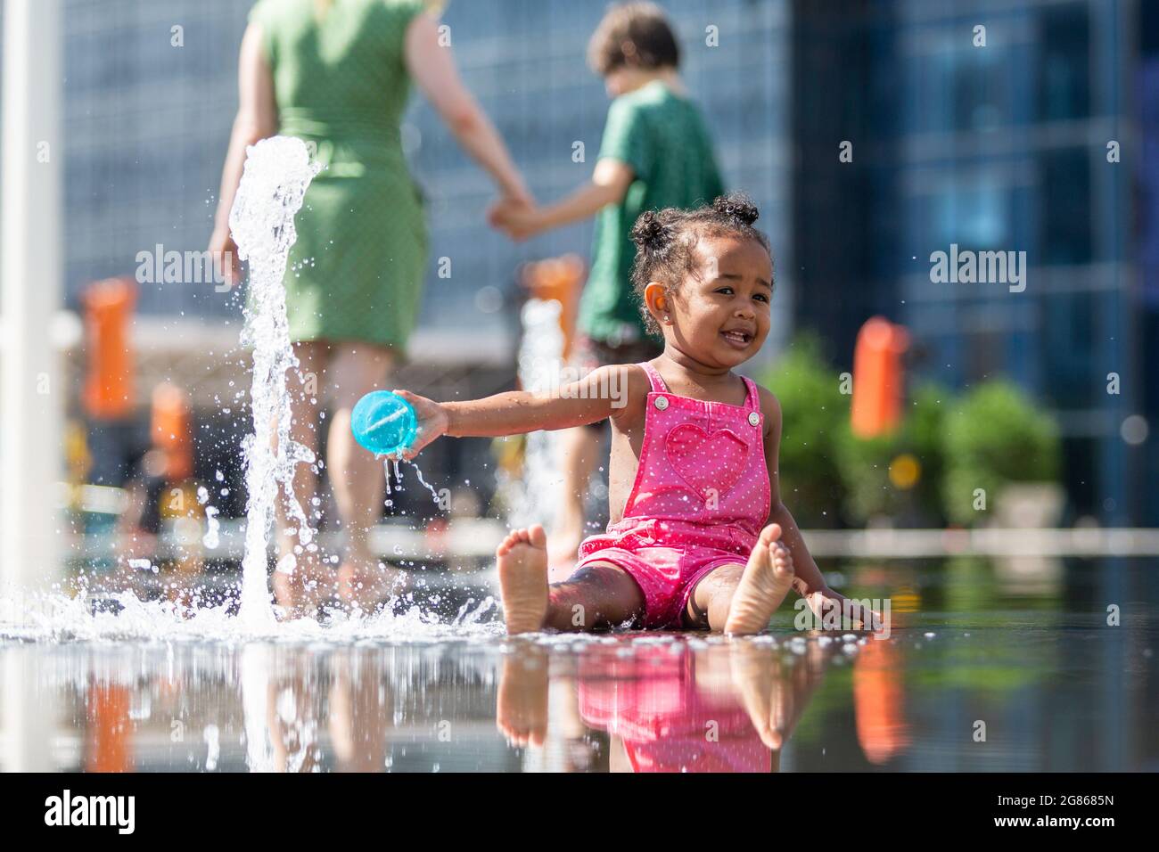 Birmingham, Großbritannien. Juli 2021. Die zweijährige Grace hat eine Spritzzeit in den Springbrunnen auf dem Centenary Square in Birmingham. Peter Lopeman/Alamy Live News Stockfoto