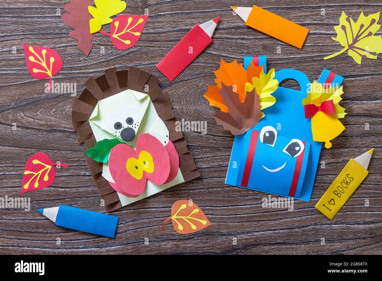 Grußkarte Igel mit einem Apfel auf einem Holztisch. Handgefertigt. Projekt der Kreativität der Kinder, Kunsthandwerk, Kunsthandwerk für Kinder. Stockfoto