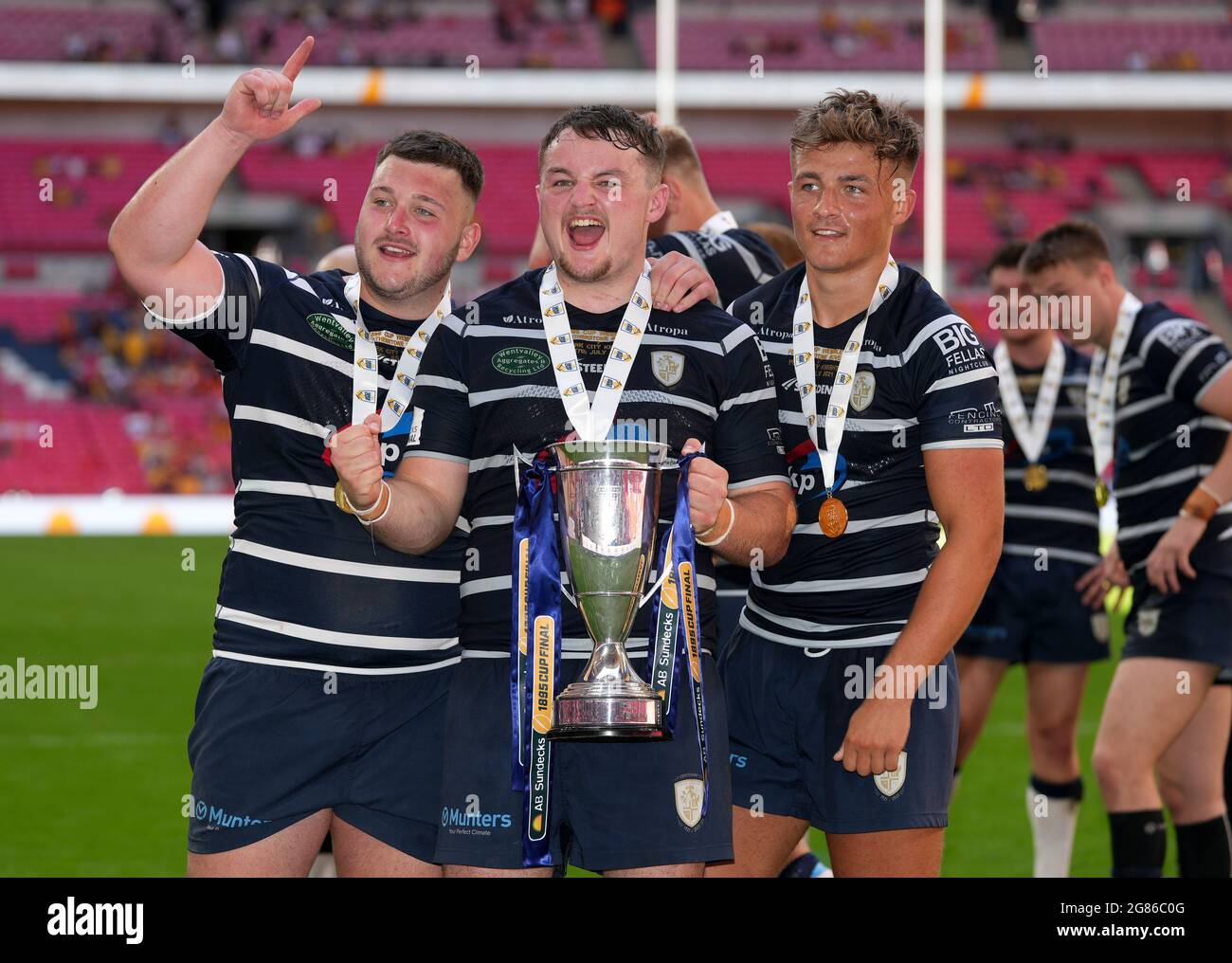 Lewis McConnell von Featherstone Rovers hält die Trophäe und feiert mit den Teamkollegen Joseph Summers (links) und Harvey Spence nach dem Cup-Finale 1895 im Wembley Stadium, London. Bilddatum: Samstag, 17. Juli 2021. Stockfoto