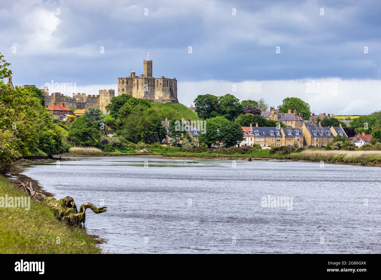 Blick über den Fluss Coquet auf das mittelalterliche Warkworth Castle und das Dorf Warkworth in Northumberland. Stockfoto