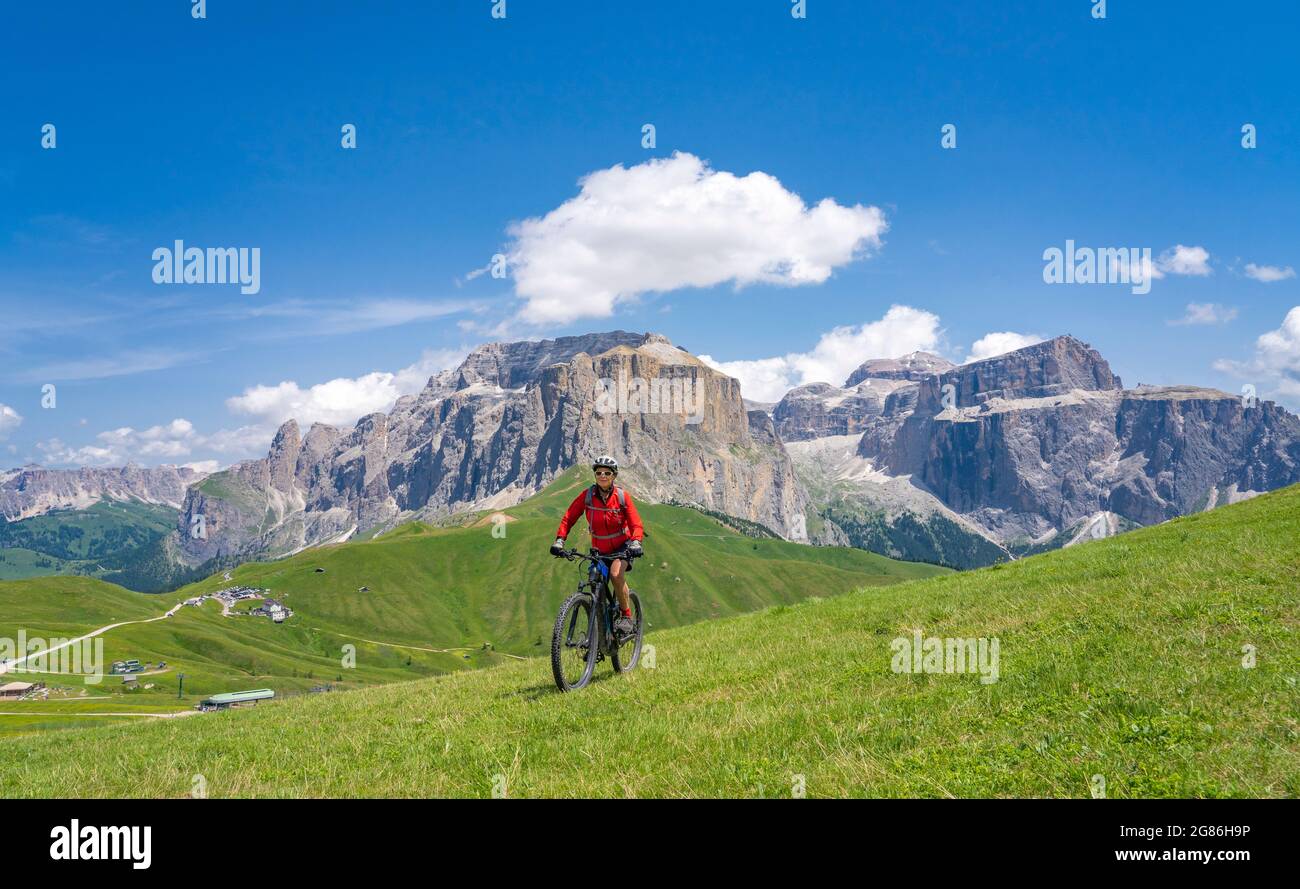 Aktive ältere Frau auf dem berühmten Sella Ronda Mountainbike Trail in der Sella Berggruppe, Wolkenstein Dolomiten, Gröden, Italien Stockfoto
