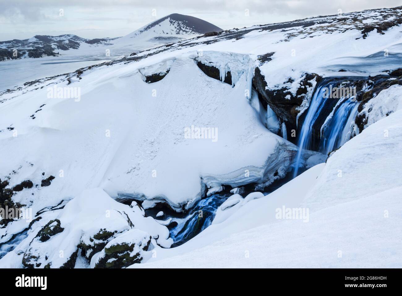 Ein Gletscherfluss bahnt sich seinen Weg durch Schnee und Eis auf der Snaefellsnes Penninsular in Westisland Stockfoto