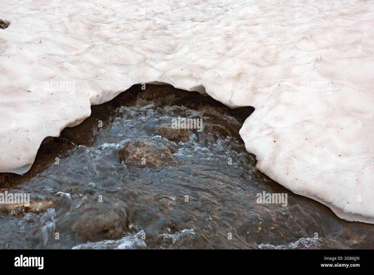 Ende des Winters, Anfang des Frühlings: Schmelzender Schnee bildet einen Fluss Stockfoto