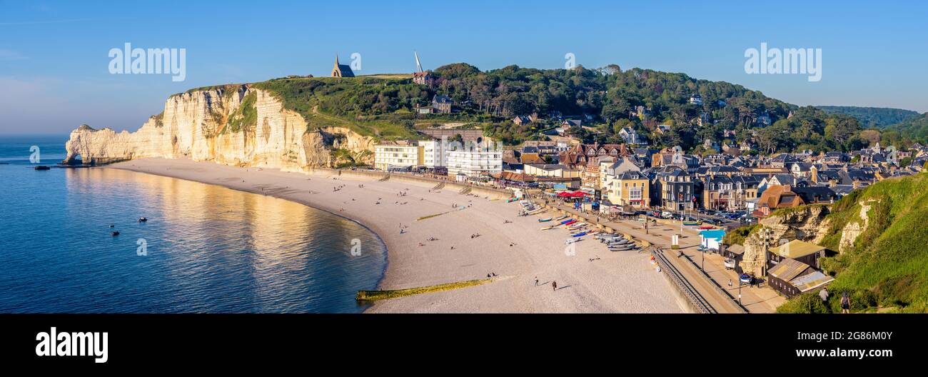 Der Strand von Etretat in der Normandie, eine beliebte Küstenstadt, die für ihre Kreidefelsen bekannt ist, mit der Kapelle Notre-Dame de la Garde mit Blick auf die Klippe von Amont. Stockfoto