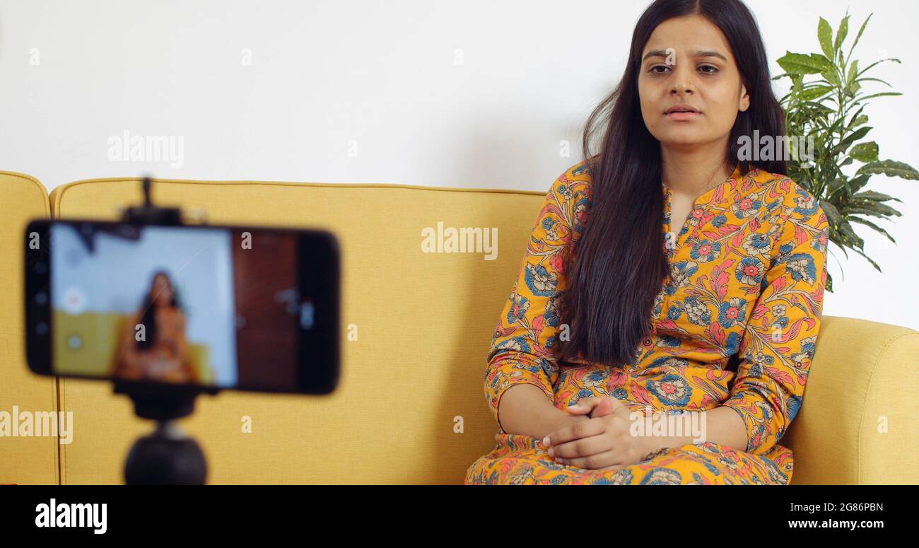 Hübsche indische Frau zeichnet ein Video auf Stockfoto