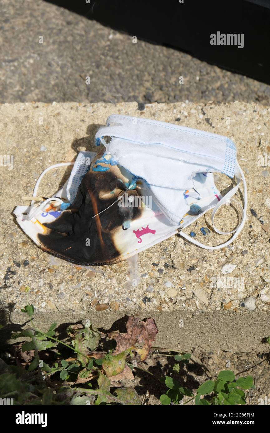 Haufen von Gesichtsmasken, die aus Protest gegen die Covid-Gesetze verbrannt wurden, West Sussex, England, Großbritannien Stockfoto