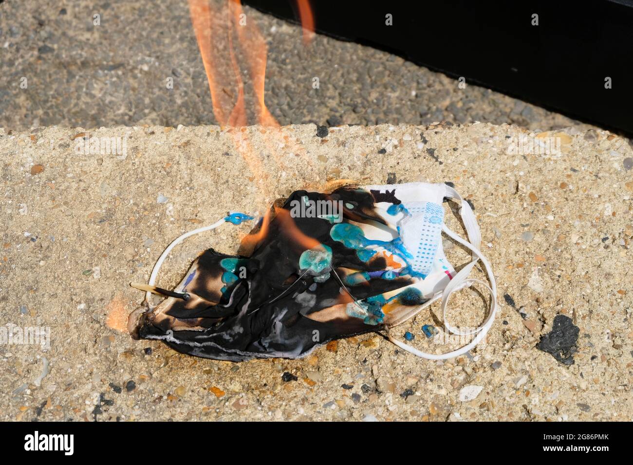 Haufen von Gesichtsmasken, die aus Protest gegen die Covid-Gesetze verbrannt wurden, West Sussex, England, Großbritannien Stockfoto