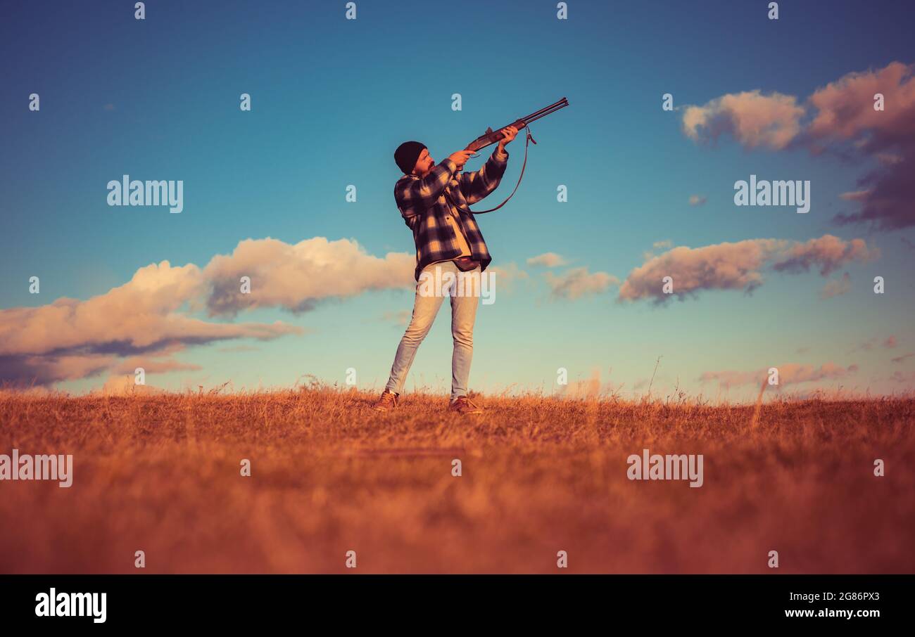 Sportliches Tonschießen und Skeet Shooting. Jäger mit Schrotflinte auf der Jagd. Autunm-Jagd. Jagd in den USA. Hunter zielt auf Gewehr im Wald. Prozess der Ente Stockfoto