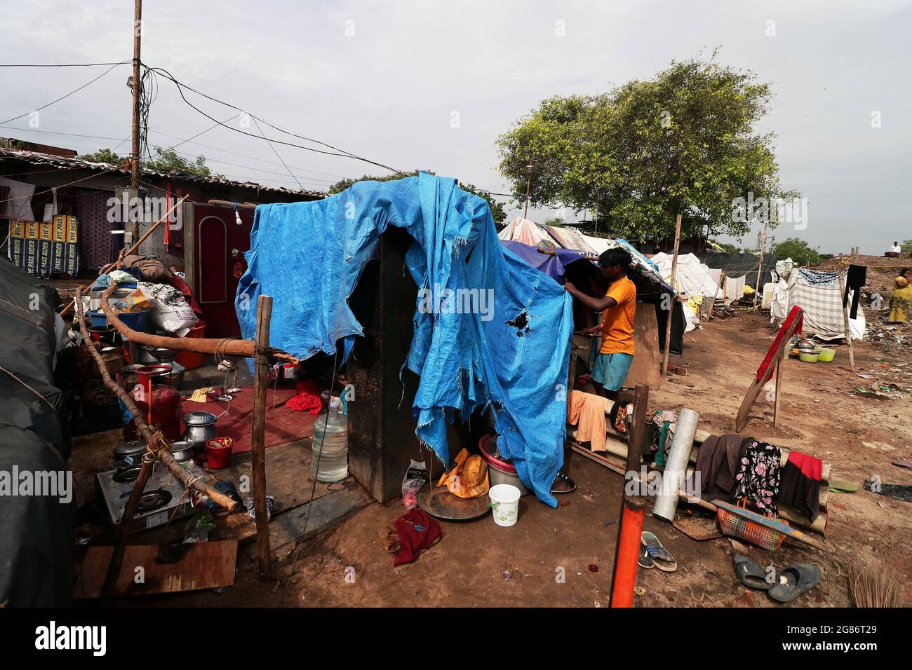 Chennai, Tamil Nadu, Indien. Juli 2021. Ein Mann in einem Slum repariert sein beschädigtes Haus nach heftigem Regen in Chennai mit einer Plane. (Bild: © Sri Loganathan/ZUMA Press Wire) Stockfoto