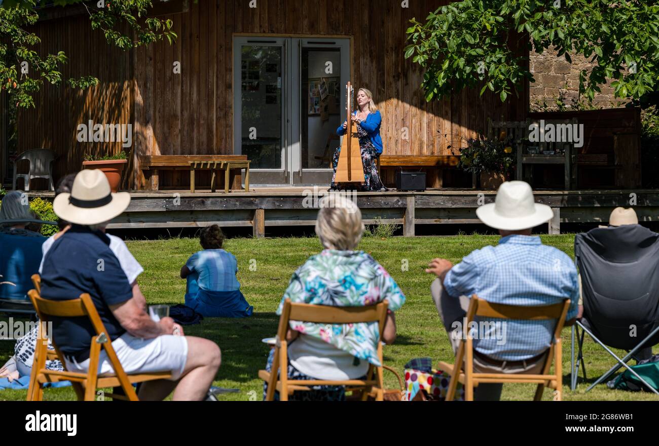 Haddington, East Lothian, Schottland, Großbritannien, 17. Juli 2021. Die keltische Harfenistin Ailie Robertson spielt im von Amisfield ummauerten Garten: Ein ausverkauftes, sozial distanziertes Konzert findet im von Freiwilligen gepflegten ummauerten Garten statt, einem der größten in Schottland. Ailie Robertson ist eine preisgekrönte Komponistin und Performerin, die traditionelle und zeitgenössische Harfenmusik spielt Stockfoto