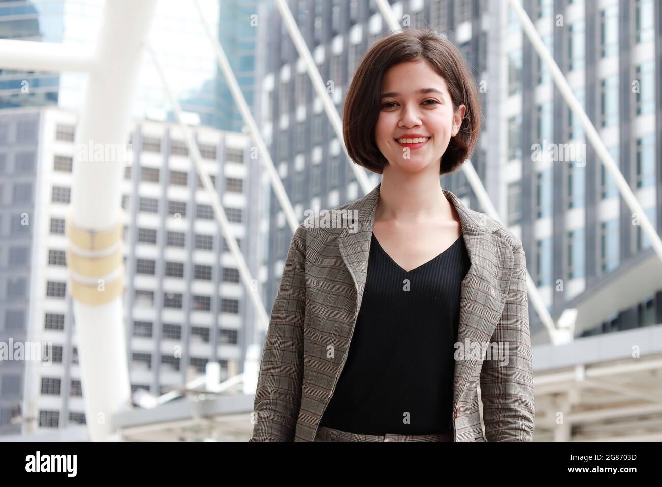 Porträt von jungen und schönen niedlichen Geschäftsfrau Halbrennen Thai-deutsche tragen Business-Anzug stehen und lächeln Blick auf die Kamera mit selbstvertrauten Stockfoto