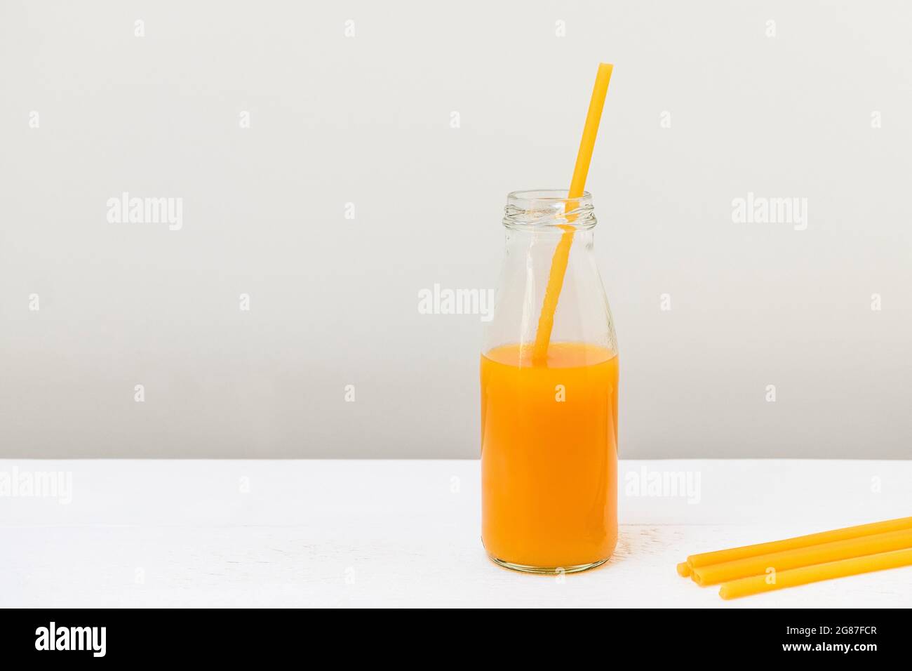 Nudelstroh in einer Glasflasche mit Pfirsichsaft, Zero Waste Konzept Stockfoto