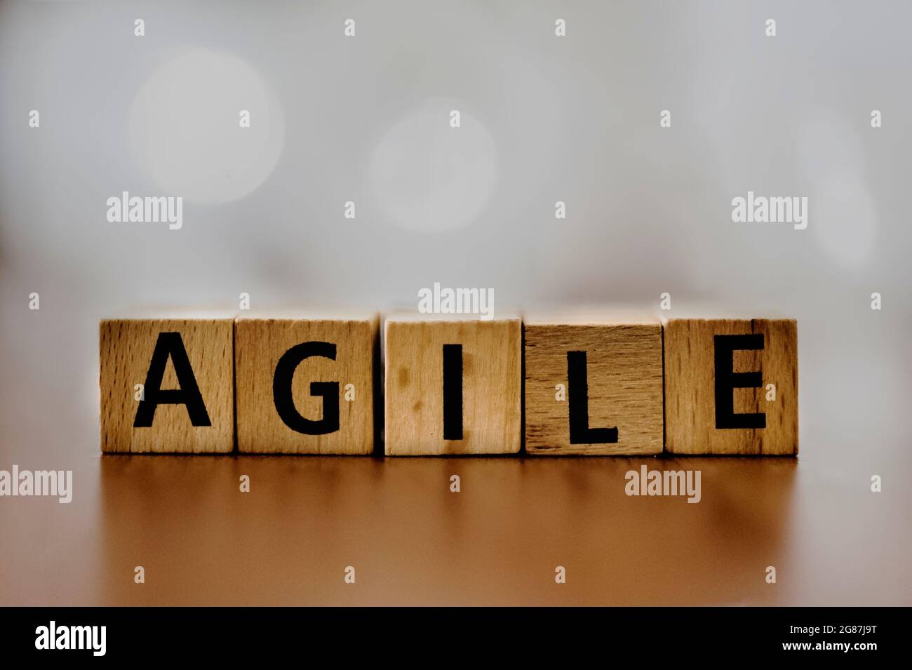 Der Orden „Agile“ wurde mit Holzblöcken vor einem sanft verschwommenen Hintergrund geschrieben. Dieses Bild zeigt das Wesen von Flexibilität und Innovation Stockfoto
