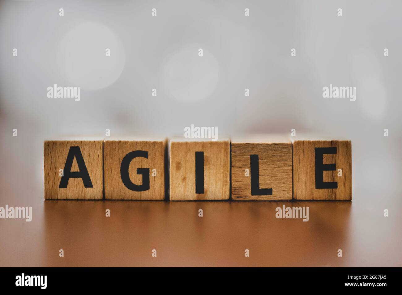 Der Orden „Agile“ wurde mit Holzblöcken vor einem sanft verschwommenen Hintergrund geschrieben. Dieses Bild zeigt das Wesen von Flexibilität und Innovation Stockfoto