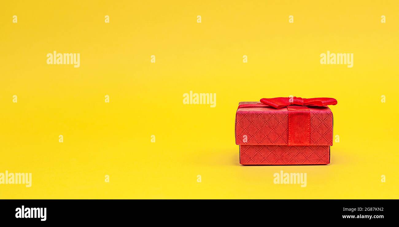 Geschenkboxen auf gelbem Hintergrund. Rote Geschenkschachteln, offene Schachtel. Postkarte zum Drucken, Banner mit Platz für Text. Stockfoto