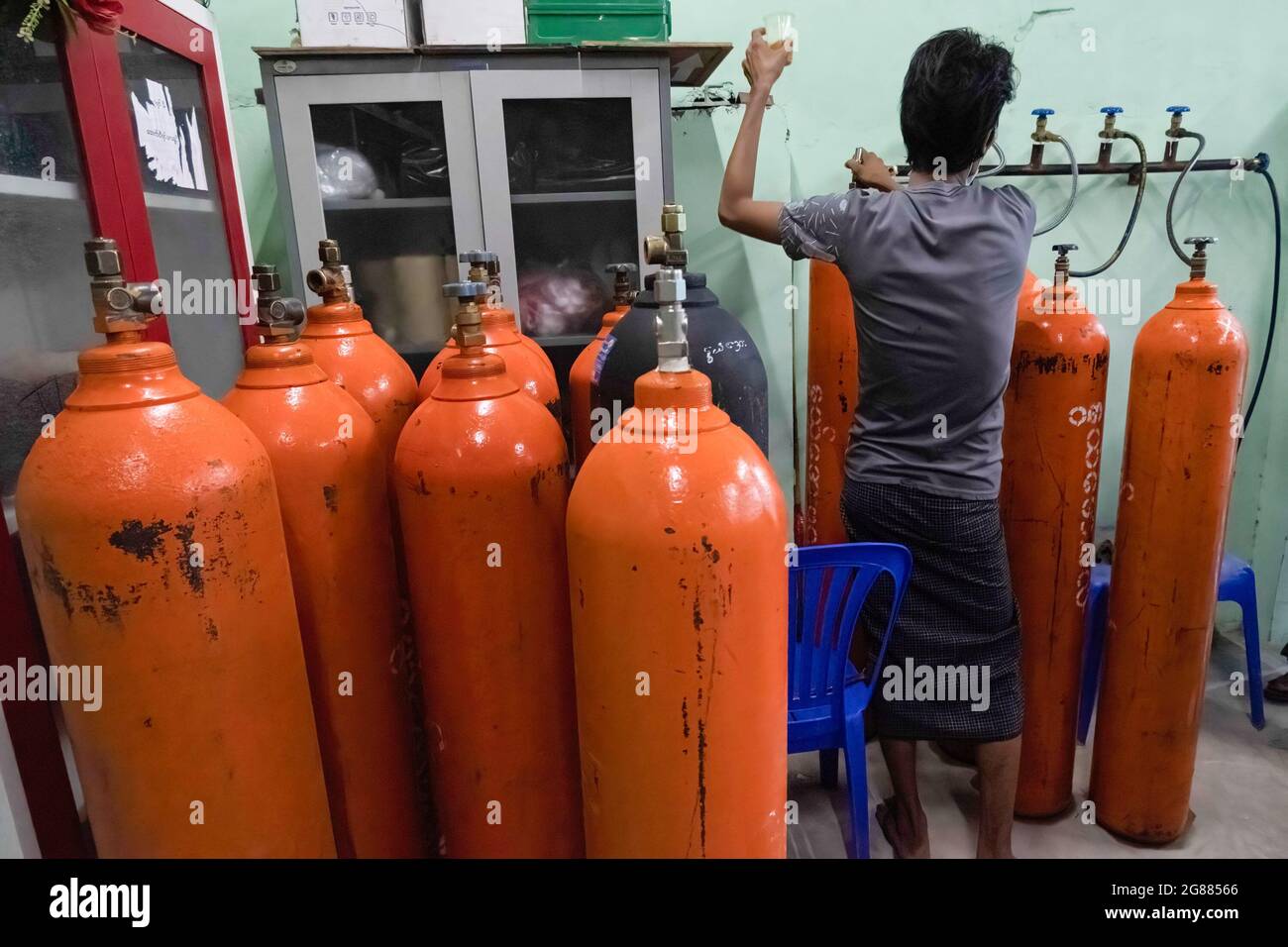 Yangon, Myanmar. Juli 2021. Ein Arbeiter sah das Nachfüllen leerer Sauerstoffflaschen im Sauerstofffüllzentrum, inmitten der Zunahme der Covid-19-Fälle.Myanmar steht in den meisten Krankenhäusern des Landes vor einem Mangel an Sauerstofftanks zur Behandlung von Patienten. Das Gesundheitsministerium von Myanmar verzeichnete seit Beginn des Ausbruchs insgesamt 213,000 Infektionen, 4,346 Todesfälle und 154,000 Genesungen. Kredit: SOPA Images Limited/Alamy Live Nachrichten Stockfoto