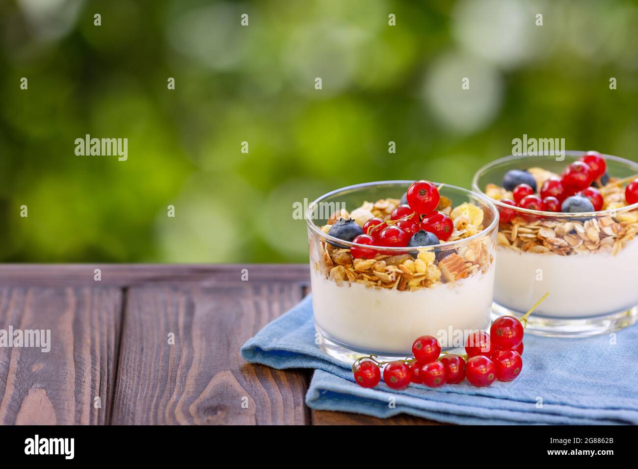 Müsli mit griechischem Joghurt und Beeren in zwei Gläsern Stockfoto