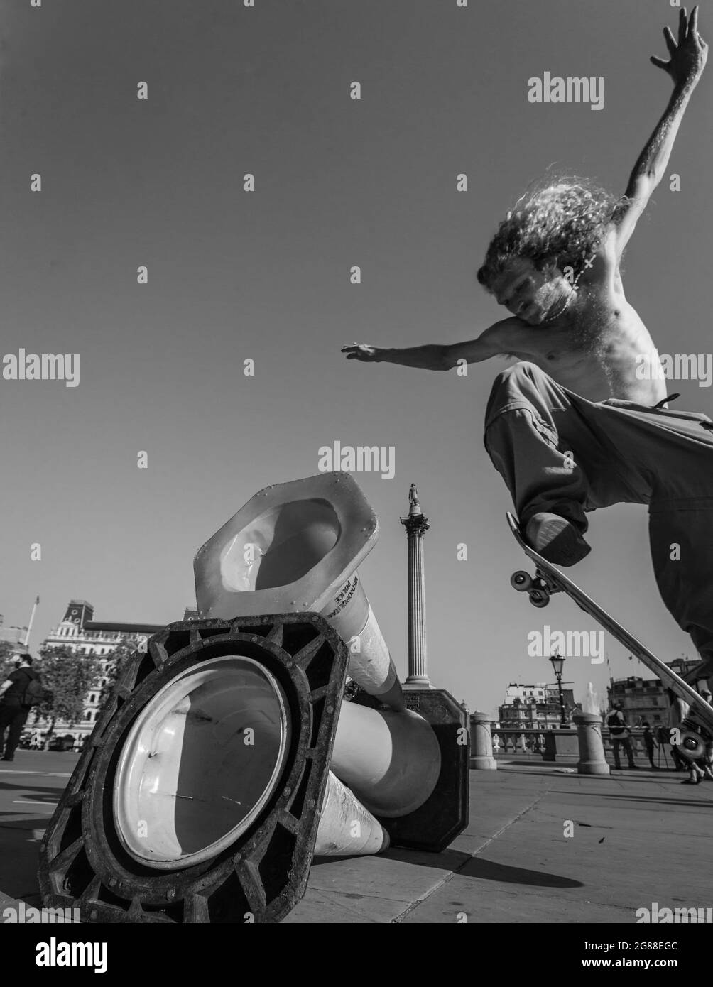 Ein Skateboarder springt auf dem Londoner Trafalgar Square über Kegel. Stockfoto