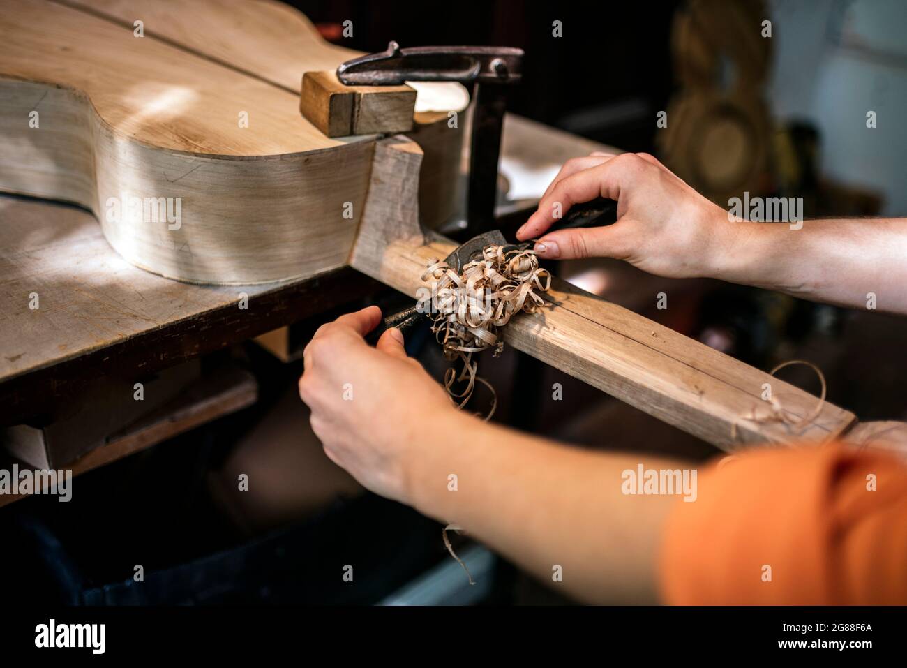 Unbekannte Geigenbauerin in traditioneller Werkstatt Stockfoto