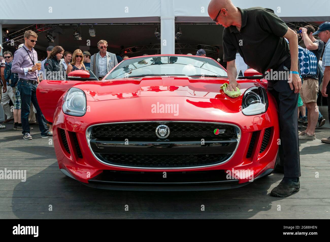 Markteinführung des Jaguar F Type S beim Goodwood Festival of Speed 2013. Die neue Grand Tourer-Version wird der Öffentlichkeit im Ausstellungsraum gezeigt. Person, die poliert Stockfoto
