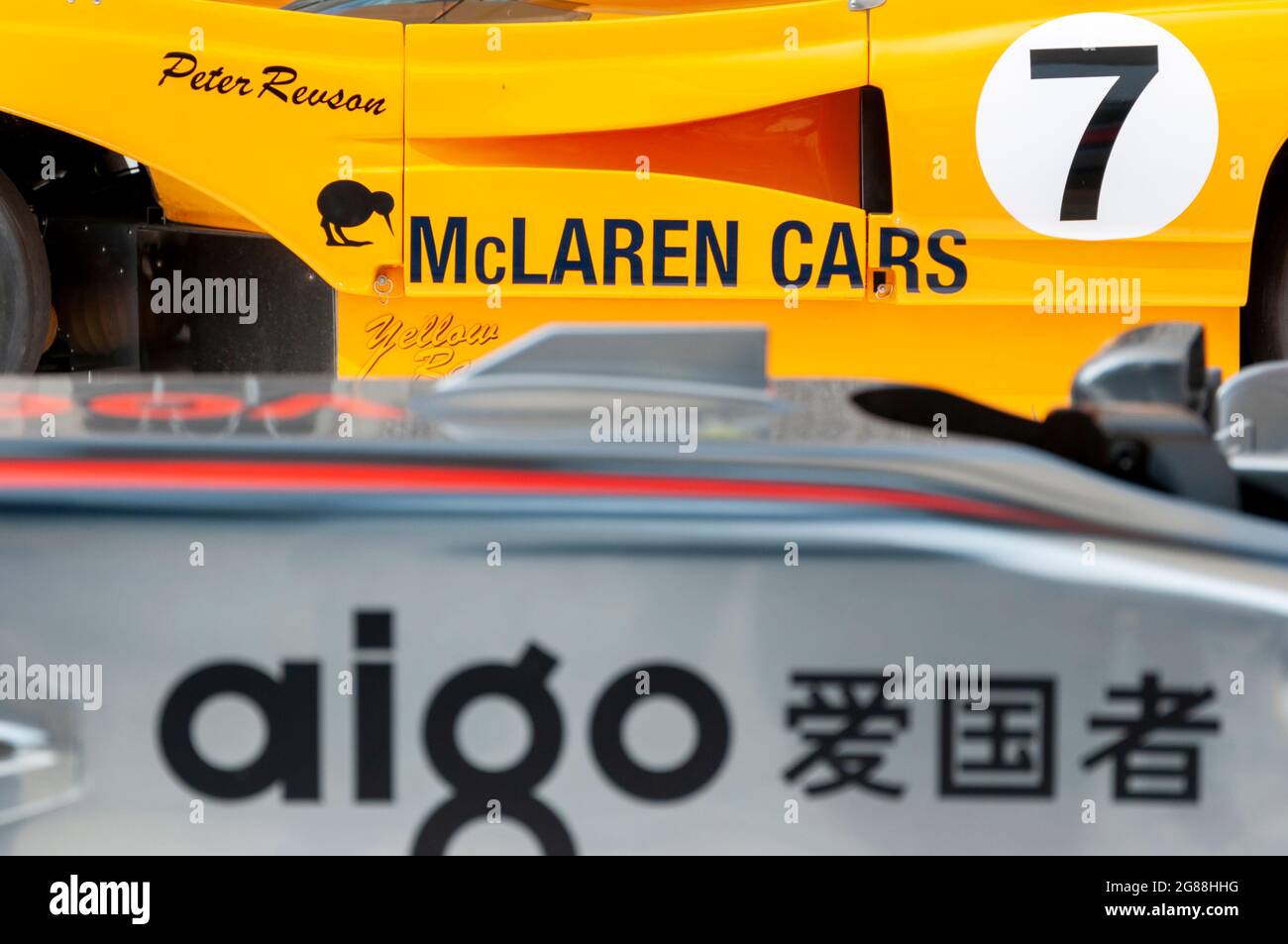 Der McLaren M8F kann auf dem Goodwood Festival of Speed 2013 von Fahrer Peter Revson ein Rennauto mit Kiwi-Symbol auf einem orangefarbenen Auto fahren. Stockfoto