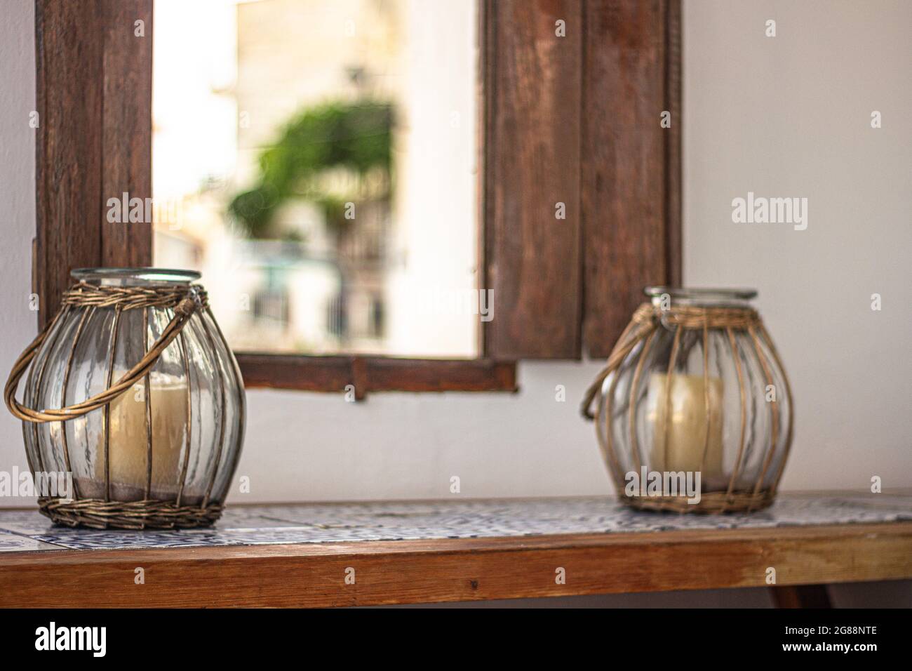 Eine selektive Fokusaufnahme von zwei Kerzenständern auf einer Fensterbank Stockfoto Eine selektive Fokusaufnahme von zwei Kerzenständern auf einer Fensterbank Stockfoto