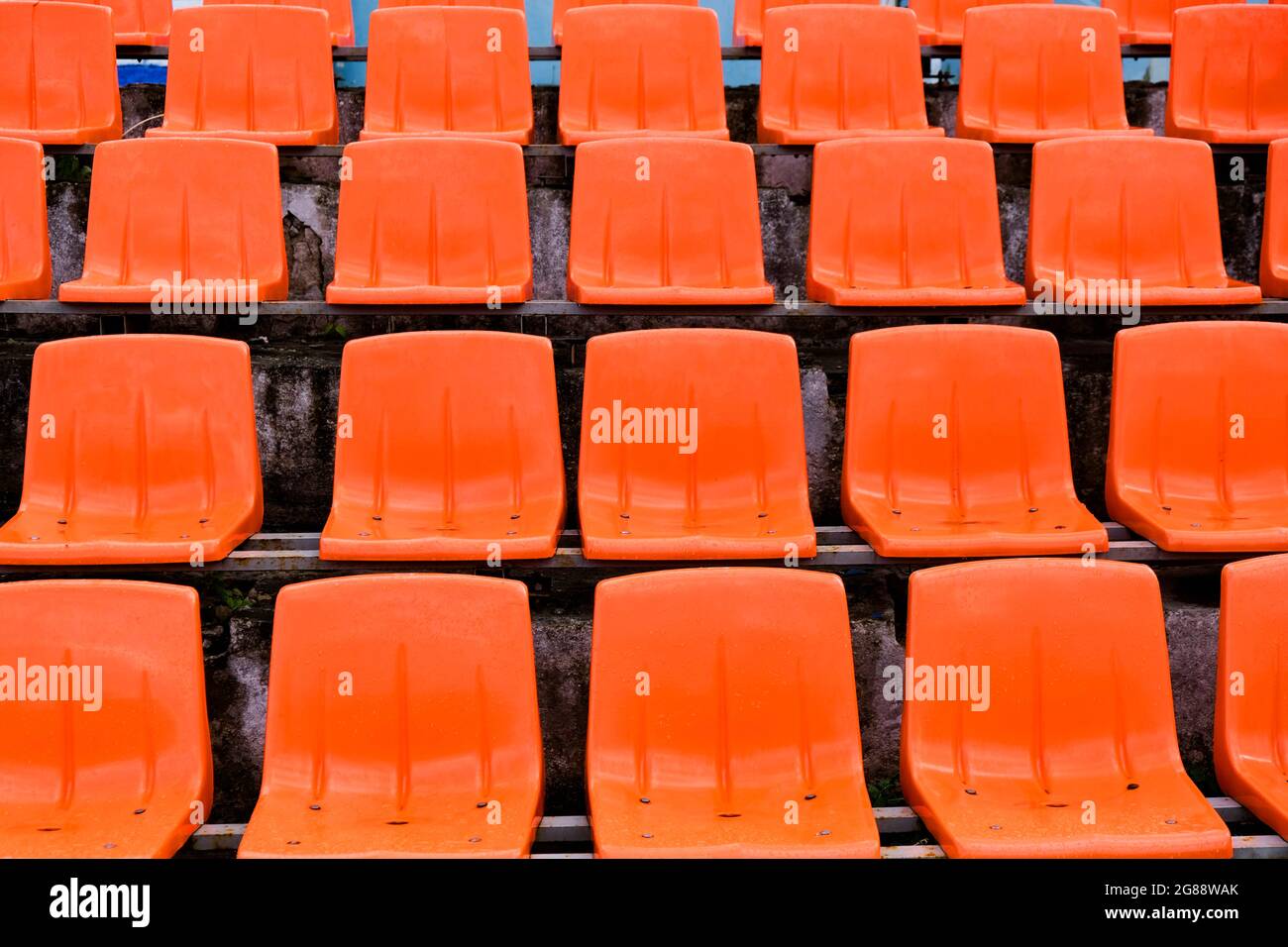 Leuchtend orange Fußballstadionsitze. Horizontale Aufnahme. Stockfoto