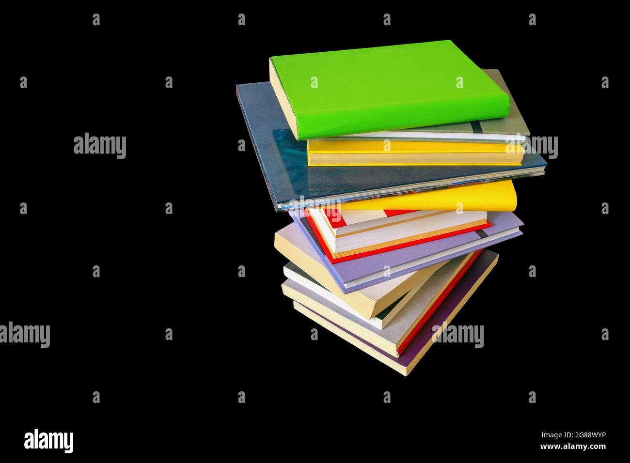 Stapel von bunten Büchern auf schwarzem Hintergrund isoliert Stockfoto