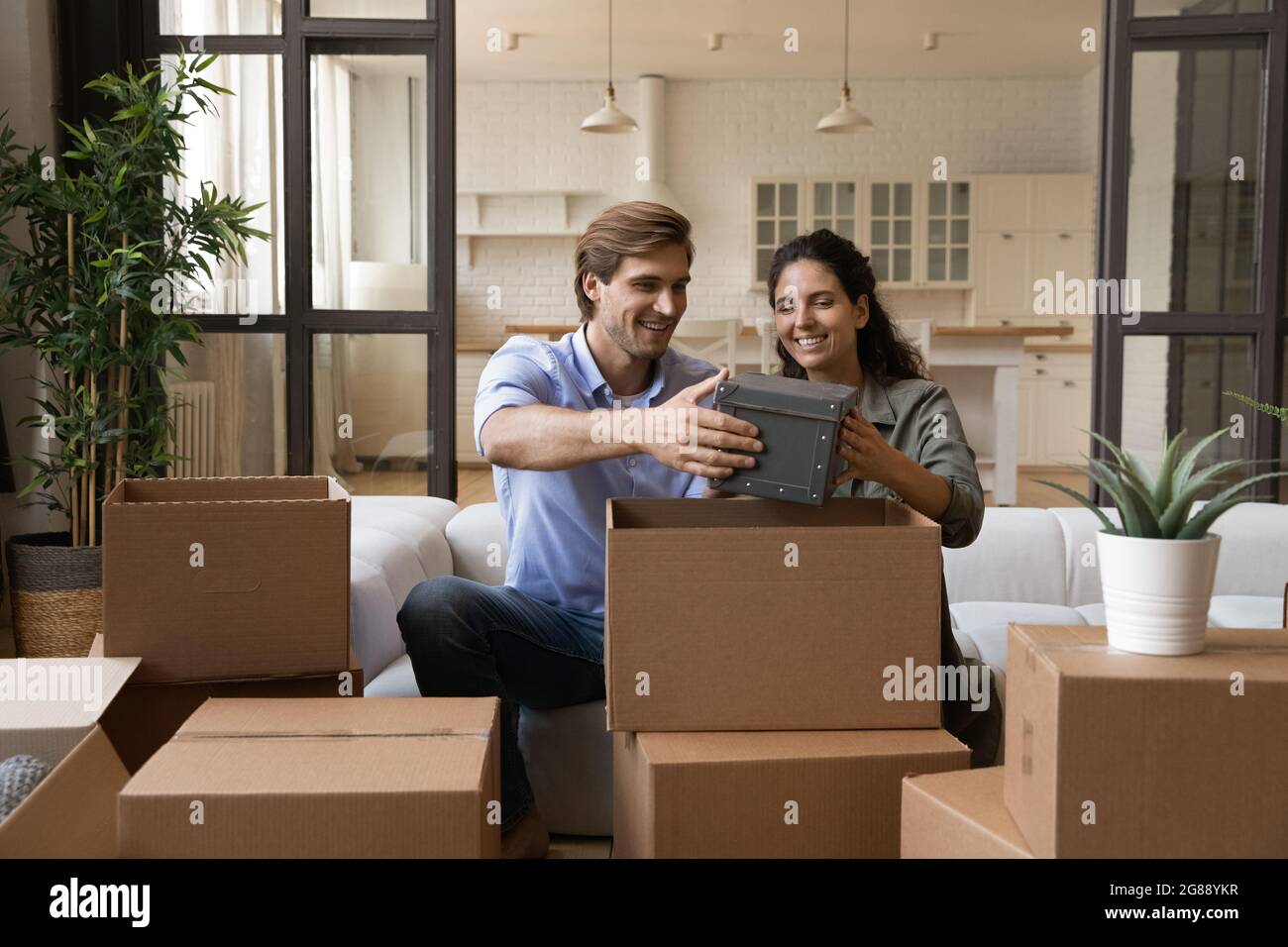 Glückliches Familienpaar, das nach dem Umzug in ein neues Zuhause Sachen auspackt Stockfoto
