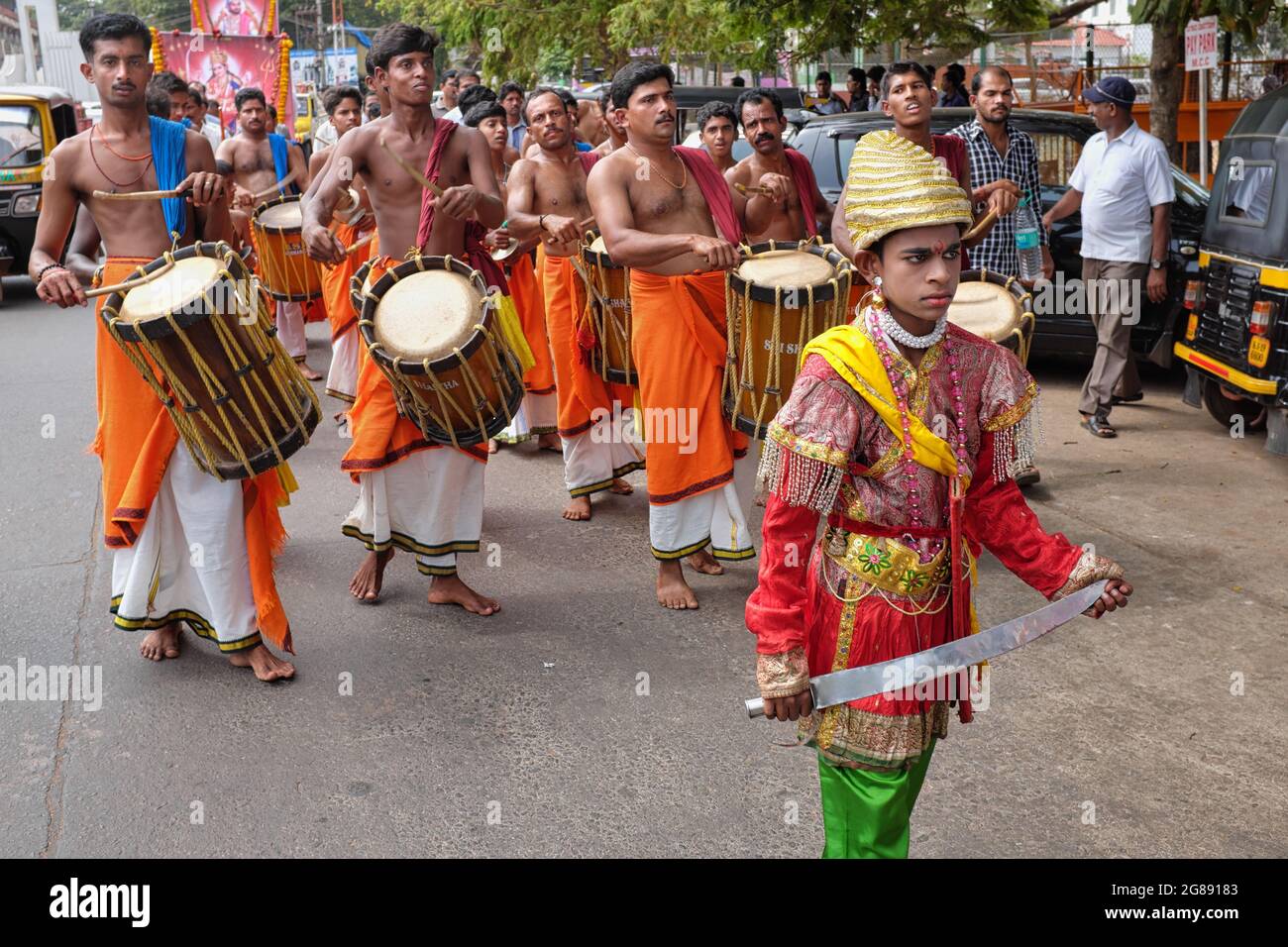 Eine Prozession von Trommlern, angeführt von einem Jungen, der als historischer Krieger gekleidet war, zur Erinnerung an ein historisches Ereignis in Mangalore (Mangaluru), Karnataka, Indien Stockfoto