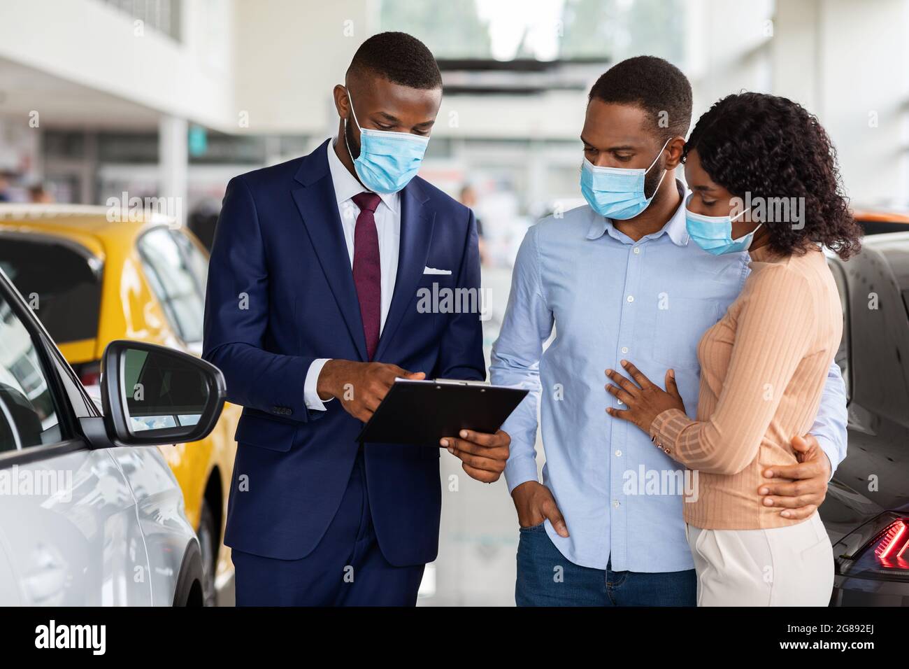 Verkäufer In Medical Mask Consulting Black Ehegatten Im Händlerzentrum Stockfoto