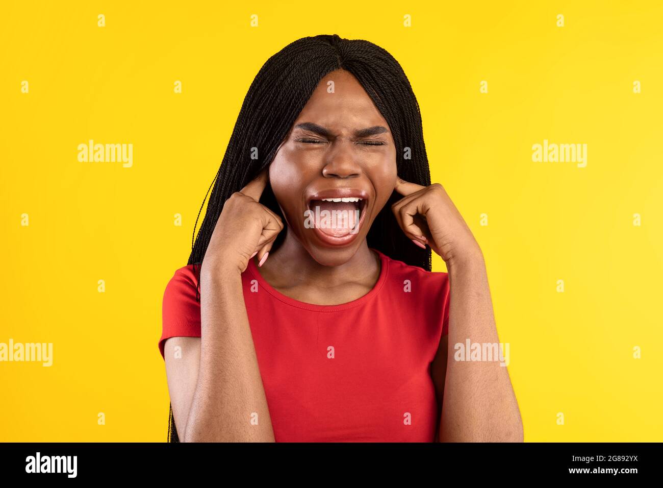 Afroamerikanische Frau Schreiend Verstopfte Ohren Mit Fingern, Gelber Hintergrund Stockfoto
