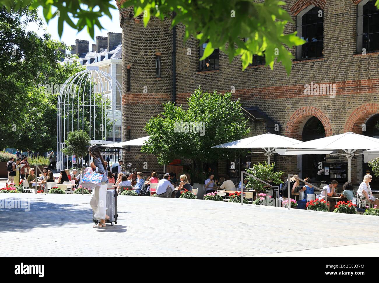 Essen im Freien im Restaurant des Deutschen Gymnasiums, am Battle Bridge Place hinter der Kings Cross Station im Norden Londons, Großbritannien Stockfoto