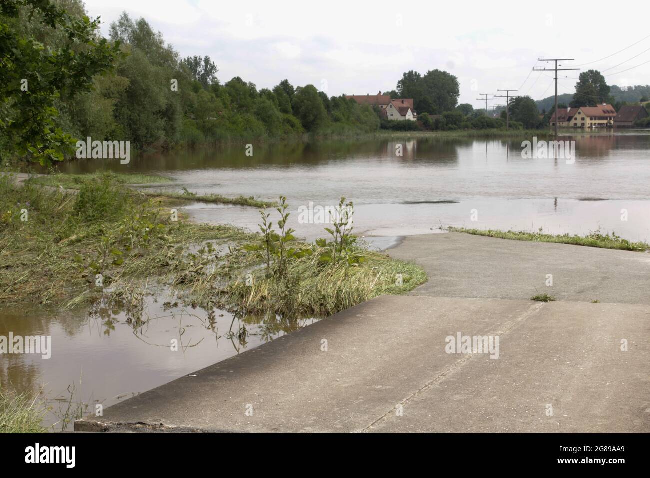 Überflutete Landschaft in Deutschland, Franken. Die Straße endet in der Ansammlung von Wasser des überfließenden Flusses Zenn nach schweren Regenfällen. Stockfoto