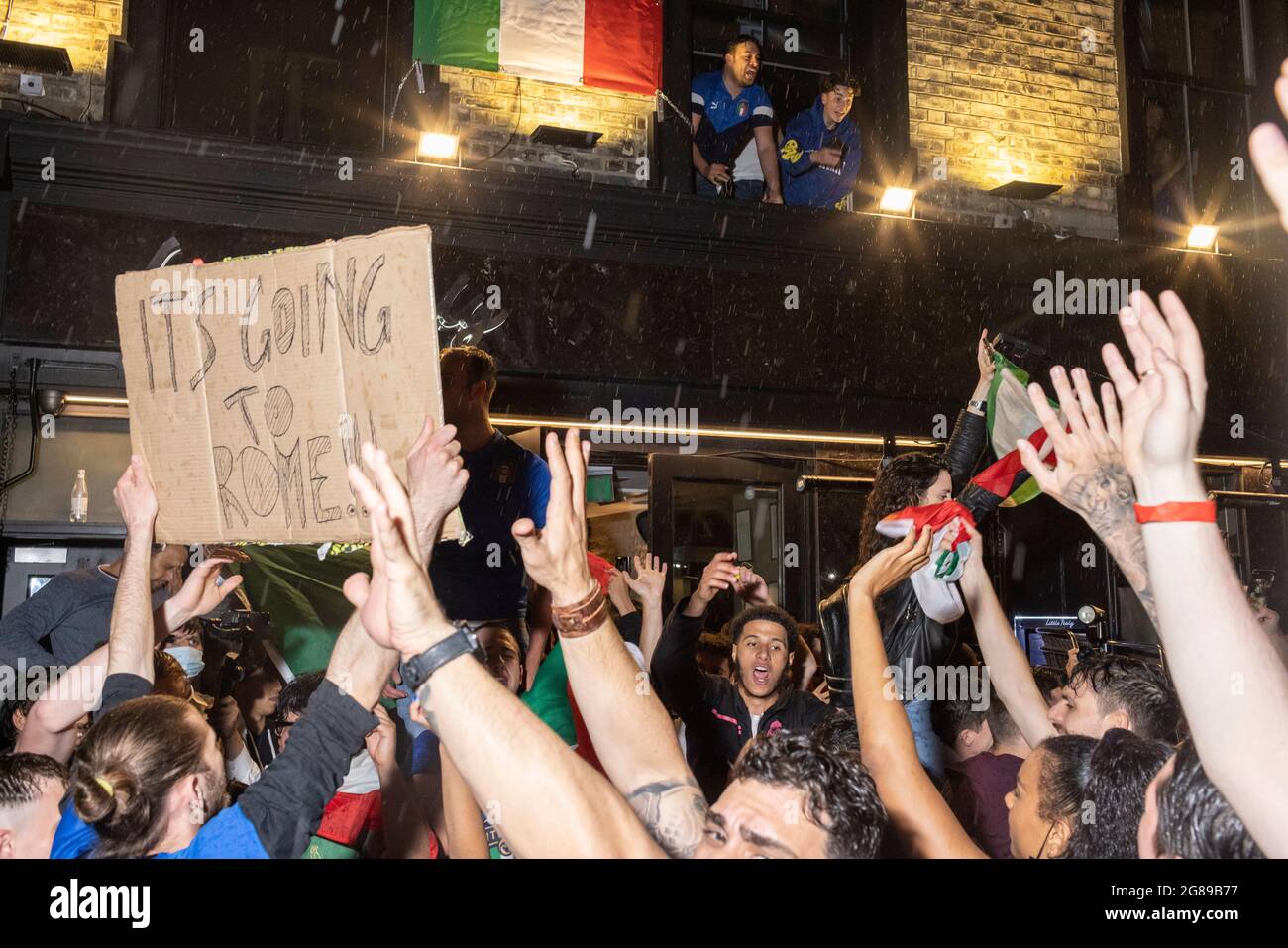 Italienische Fans feiern den Sieg im Finale der EM 2020 zwischen England und Italien vor dem Little Italy Restaurant, London, 11. Juli 2021 Stockfoto