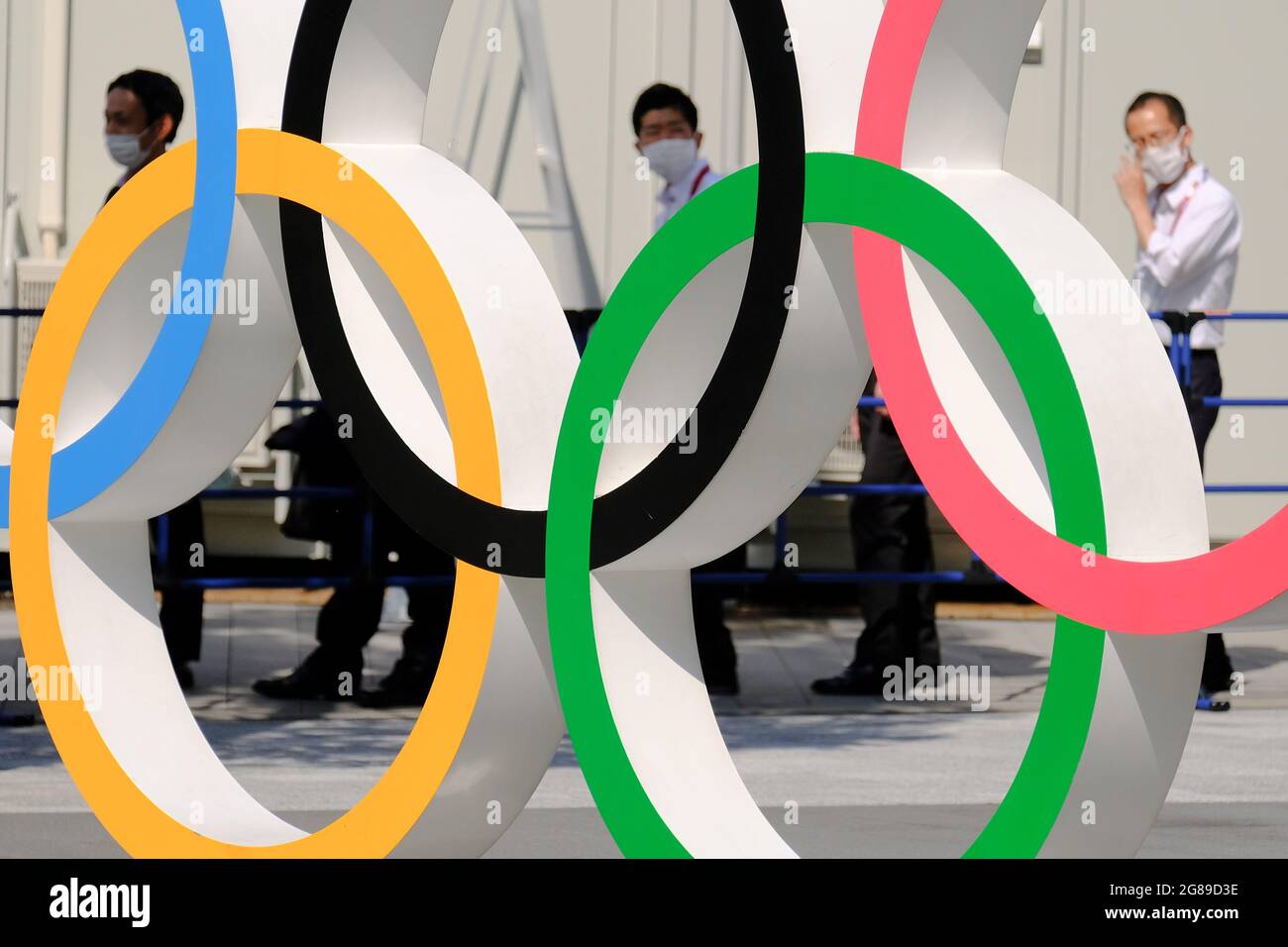 Tokio, Japan. Juli 2021. Menschen mit Gesichtsmasken laufen an den Olympischen Ringen in der Nähe des Nationalstadions in Tokio vorbei. (Foto von James Matumoto/SOPA Images/Sipa USA) Quelle: SIPA USA/Alamy Live News Stockfoto