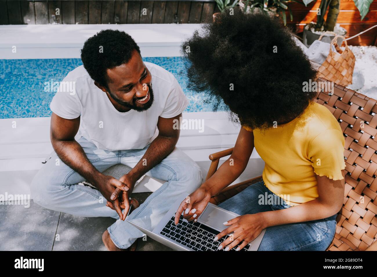 afroamerikanisches Paar zu Hause im Garten - schönes schwarzes Paar, das Zeit zusammen verbringt, ein Video online auf Computer-Laptop anzuschauen Stockfoto