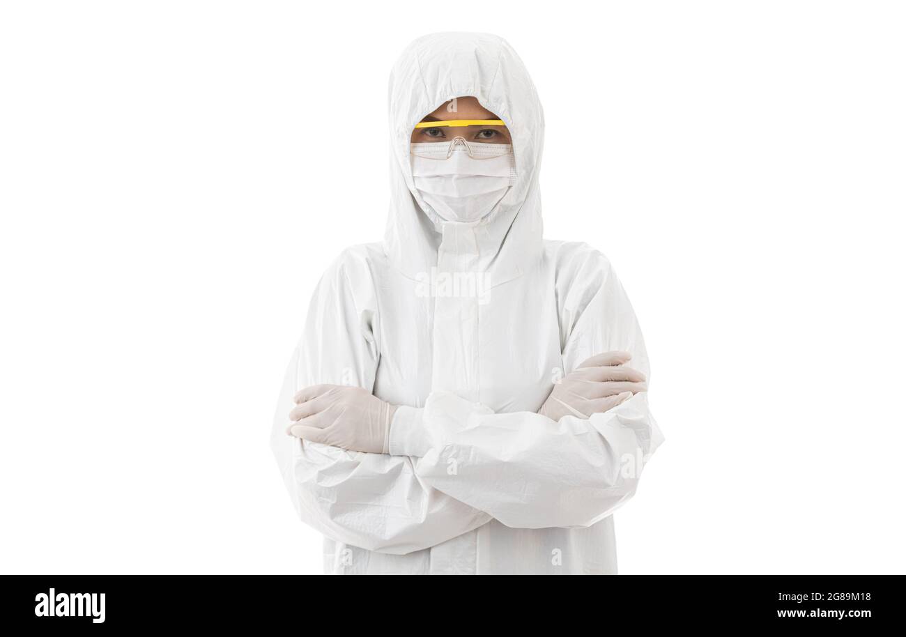 Frau in sterilisiertem Labormantel und Schutzbrille, die auf weißem Hintergrund die Kamera anschaut und die Arme kreuzt. Idee für sauber und sicher von Stockfoto