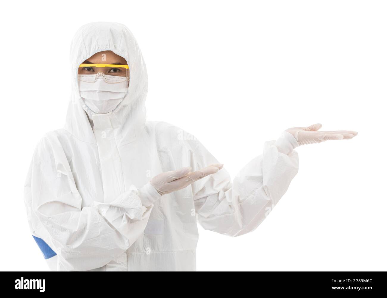 Frau in sterilisiertem Laborkittel und Sicherheitsbrille, die auf weißem Hintergrund isoliert und mit dem Finger auf den Platz zeigt und auf die Kamera schaut. Idee Stockfoto