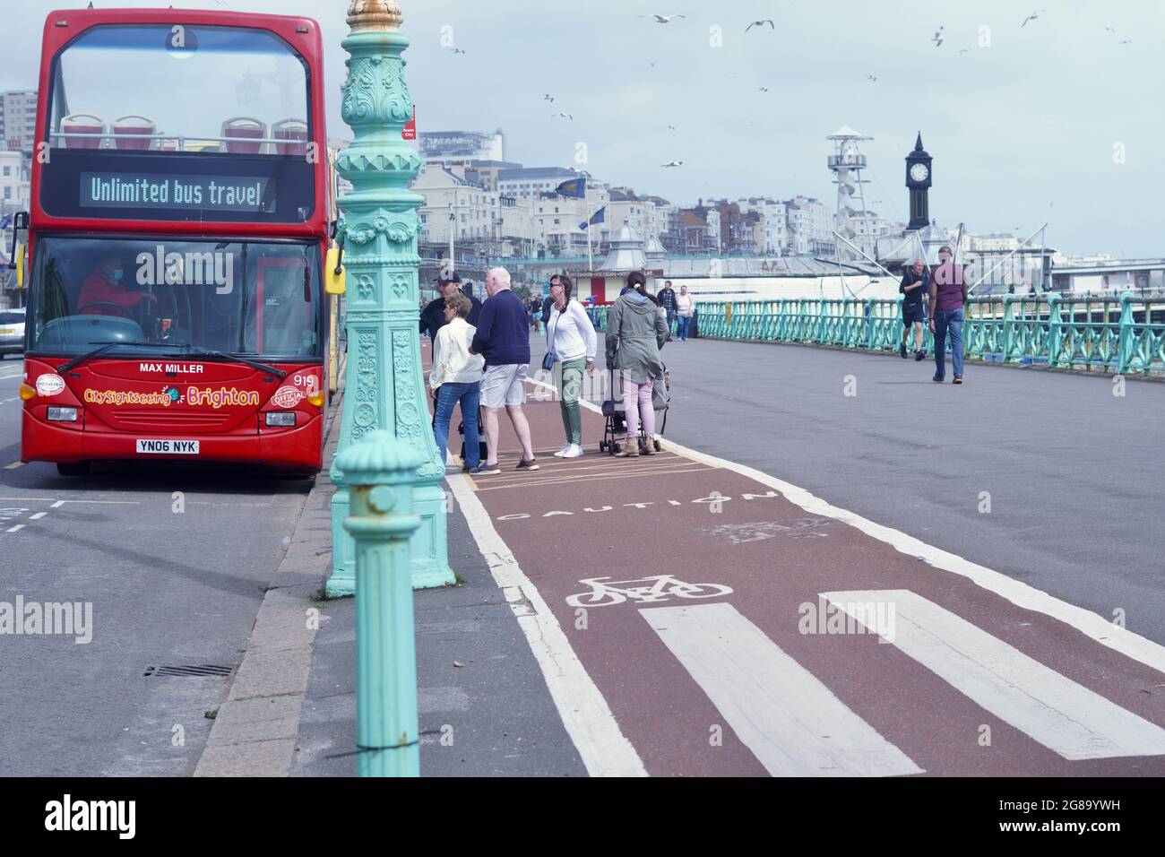Farbenfrohe Doppeldecker-Reisebusse warten an den Bushaltestellen, um Passagiere für ihre Fahrten entlang der Küste von Brighton nach Eastbourne abzuholen Stockfoto