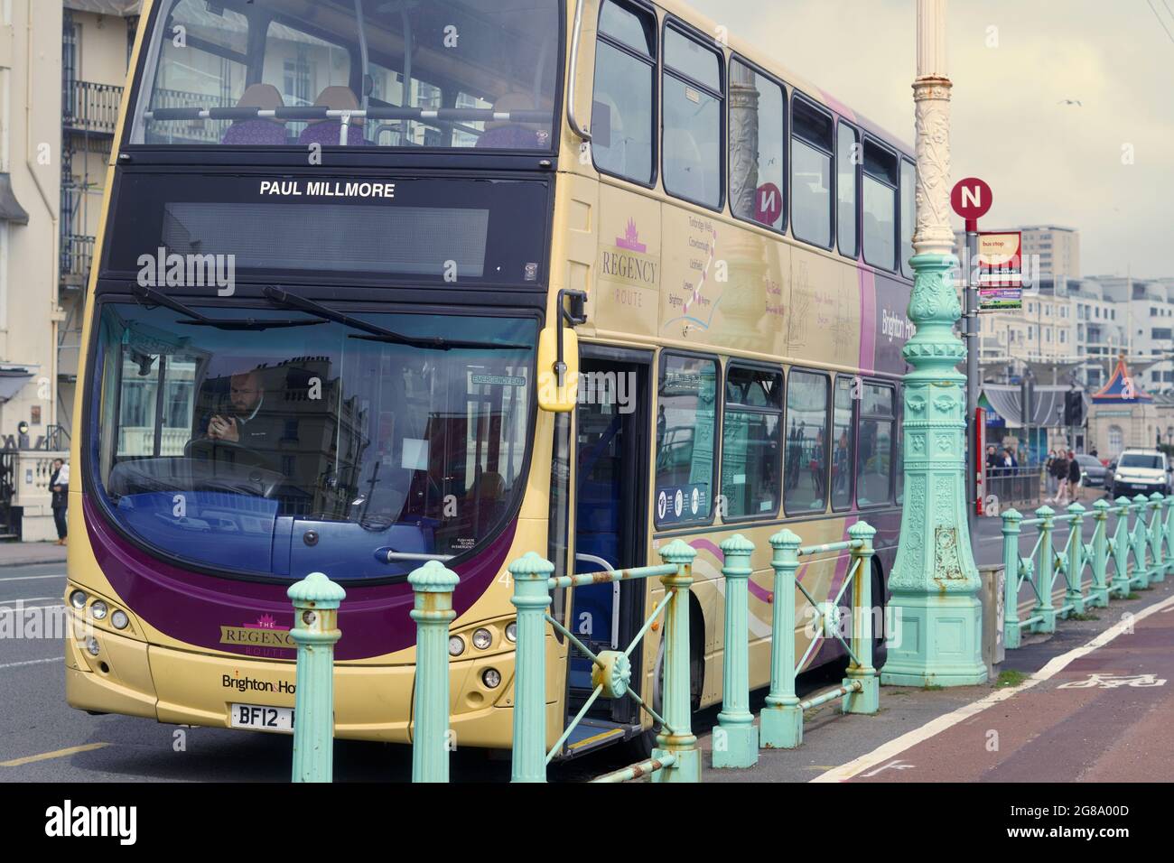 Farbenfrohe Doppeldecker-Reisebusse warten an den Bushaltestellen, um Passagiere für ihre Fahrten entlang der Küste von Brighton nach Eastbourne abzuholen Stockfoto