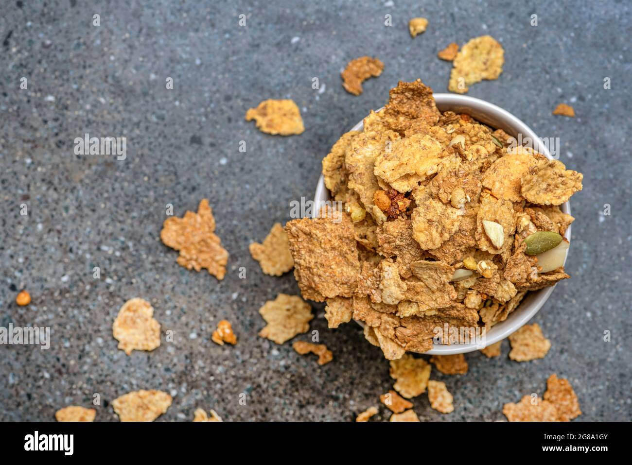 Das Müsli in einer Untertasse auf dem Hintergrund einer Steinplatte trocknen. Gesunde Ernährung und leichte Ernährung Frühstück Konzept, Copy Space Stockfoto