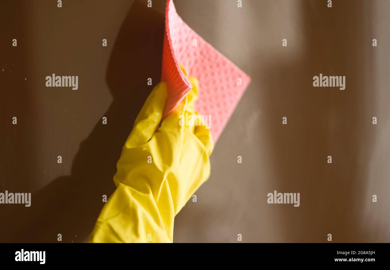 Eine Frau in gelben Gummihandschuhen macht Hausarbeit Stockfoto