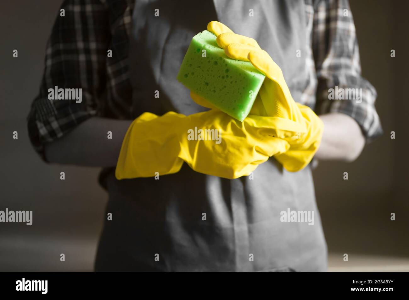 Eine Frau in gelben Gummihandschuhen macht Hausarbeit Stockfoto