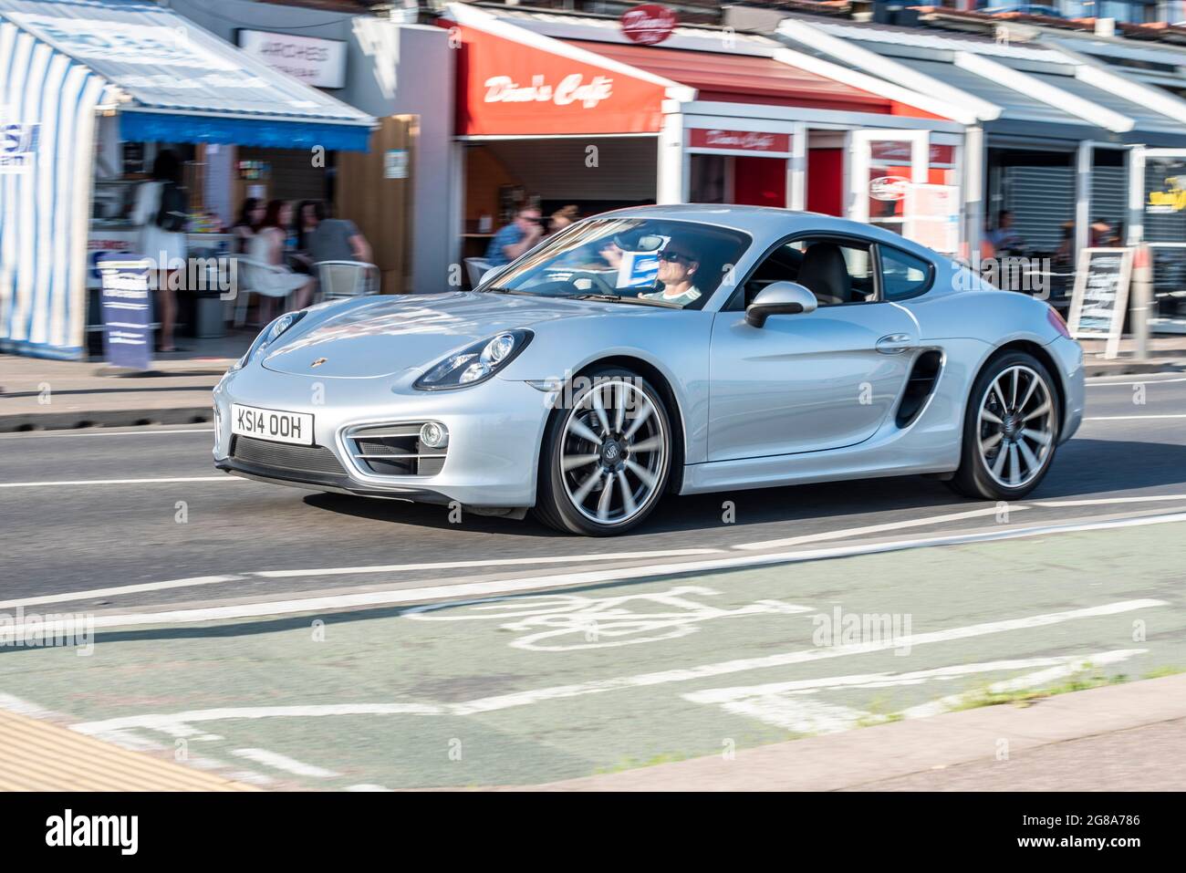 Porsche Cayman fährt an einem heißen Sommertag entlang der Küstenstraße in Southend on Sea, Essex, vorbei an Arches Cafés. 2014 registriert Stockfoto