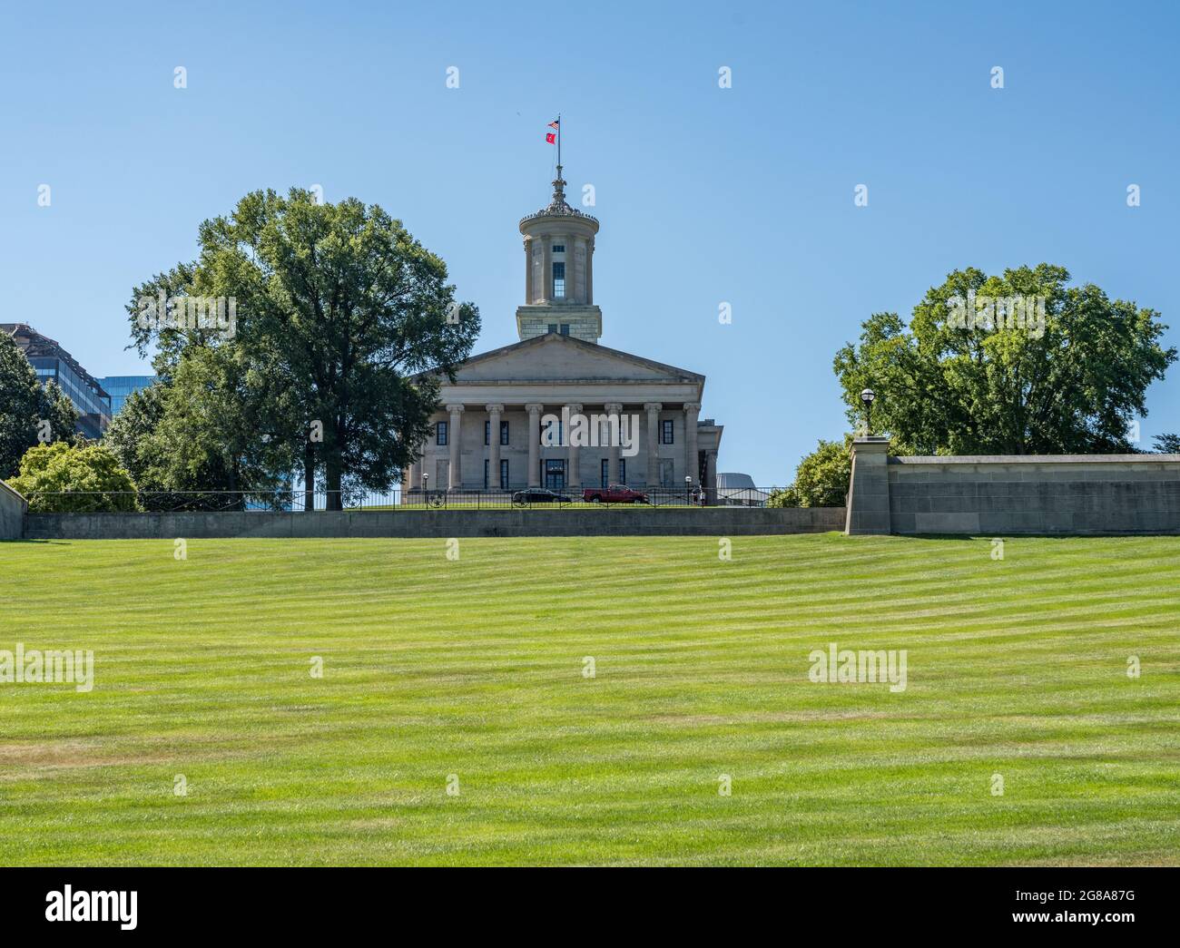 Rasen und Hügel des Tennessee State Capitol Gebäudes in Nashville mit dem Geschäftsviertel Stockfoto