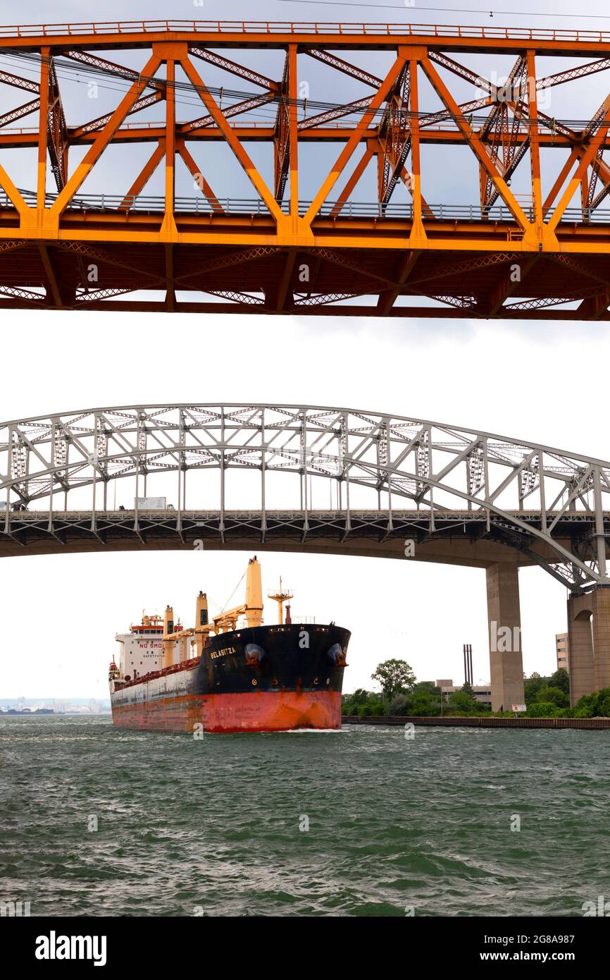 Frachtschiff, das unter der Burlington Canal Lift Bridge und dem Burlington Bay James N. Allan Skyway vorbeifährt. Burlington, Ontario, Kanada. Stockfoto